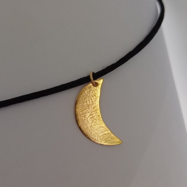 Notre pendentif, modèle demi lune petit, en plaqué or. Sur cordon noir.