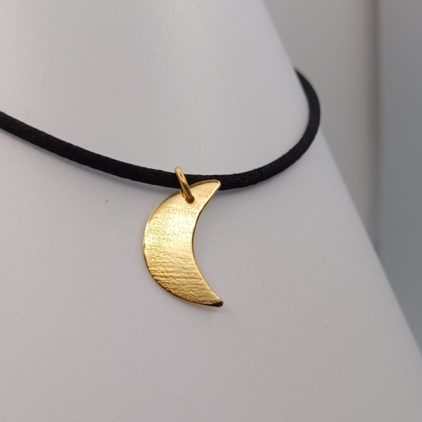 Notre pendentif, modèle demi lune moyen, en plaqué or. Sur cordon noir.