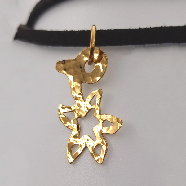 Notre pendentif, modèle fleur de Noël, en plaqué or. Sur cordon noir.