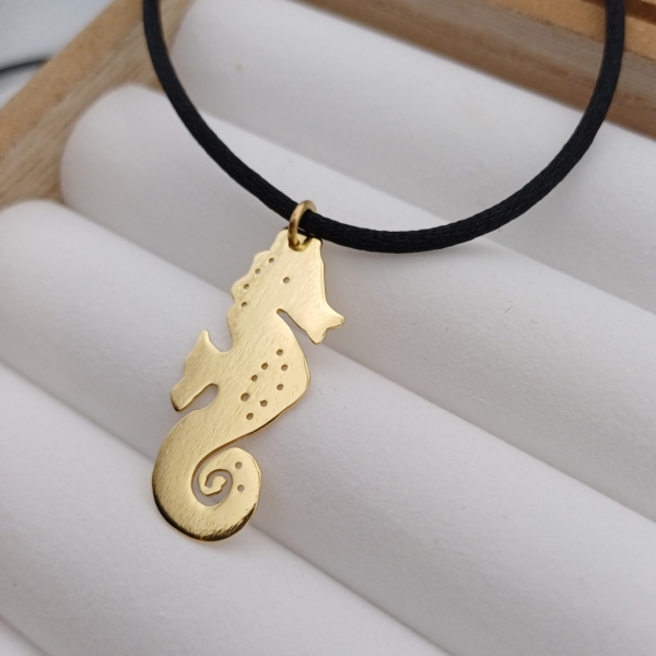 Notre pendentif, modèle Mon Hippocampe, en plaqué or. Sur cordon noir.