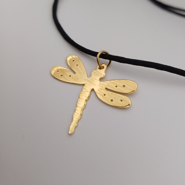 Notre pendentif, modèle Libellule, en plaqué or. Sur cordon noir.