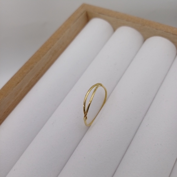 Notre bague pour femme, modèle double anneau en plaqué or, disposé sur un présentoir à bijoux.