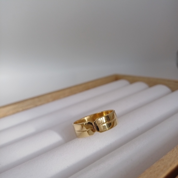 Notre bague, modèle double sens en plaqué or, disposé sur un présentoir à bijoux.